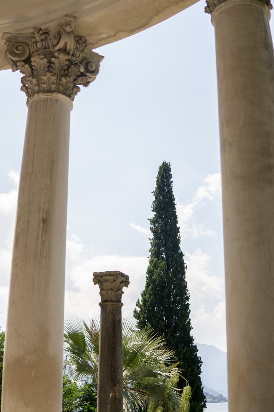 Marble columns framing a cypress against the sky